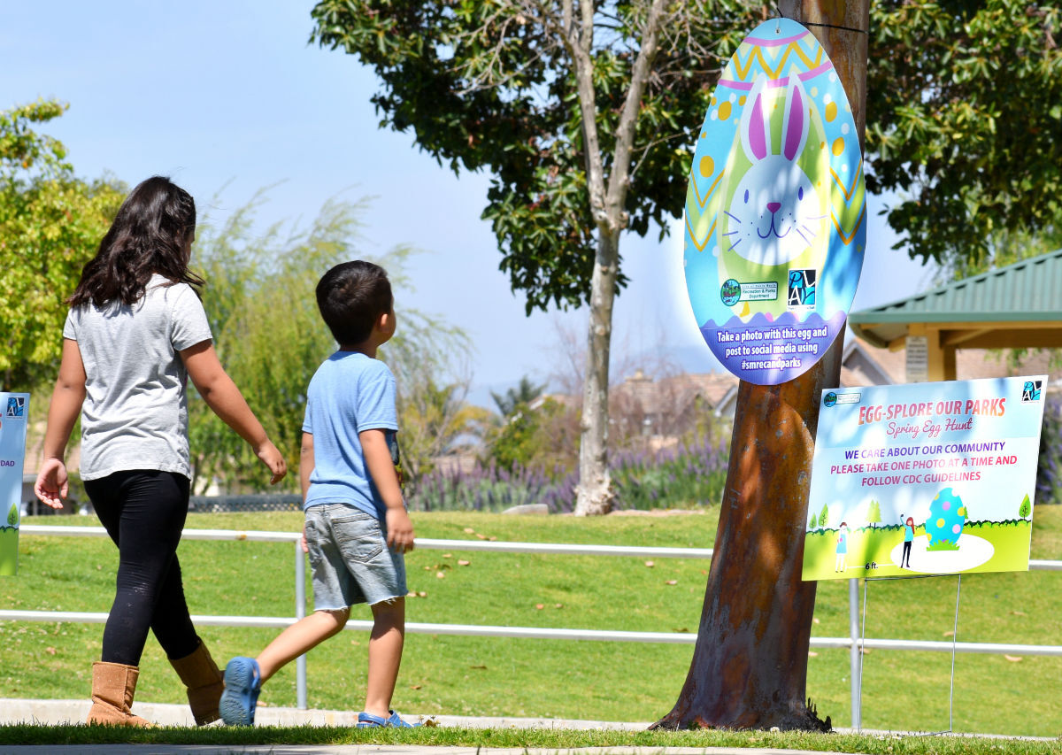 Marla left and Roberto Ibarra discover the hidden Easter egg at Rotary Park in Santa Maria Friday.